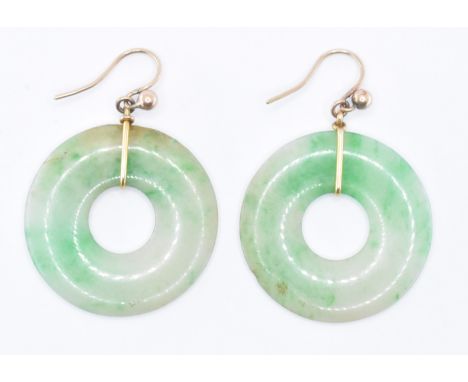 A pair of 9ct gold and jade roundel earrings. The earring having gold hooks with round jade drops and pierced centres. Measur