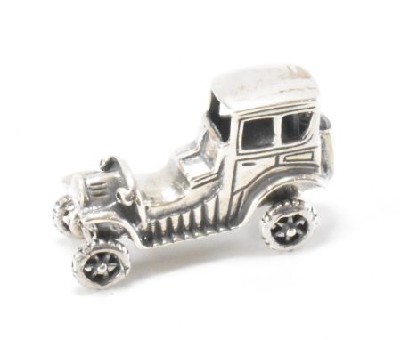 A silver figure of a classic car. The automobile having articulated wheels and being stamped 925 to the base. Measures 2cm ta