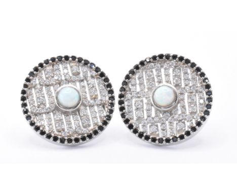 A pair of silver Art Deco style earrings having central opalite cabochons surrounded by CZ's with a halo of black stones to t