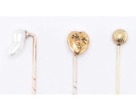 A group of three late 19th Century Victorian stick pins to include one set with a baroque pearl, one having a heart finial wi