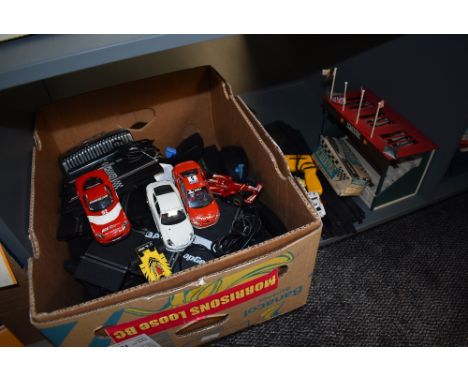 A shelf of moden Scalextric track, cars and controllers along with a empty early box C-82 Lotus and a similar period Grandsta