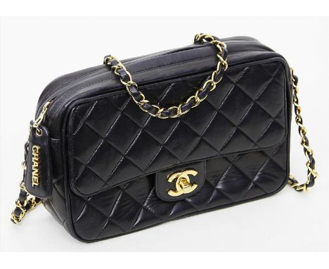   Camera Bag, Chanel.  Gestepptes, schwarzes Lammleder. Goldfarbene Hardware. Reißverschluss und Überschlag mit Chanel Monog.