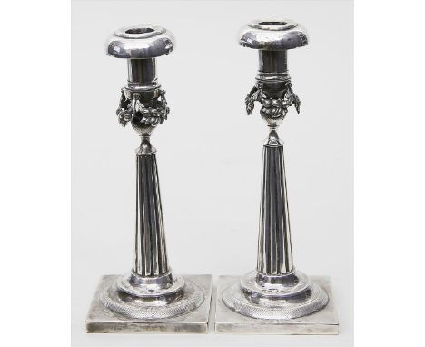   Paar Empire-Leuchter,  je einflammig. Lötiges Silber, 552 g. Gegossen und getrieben. Kannelierte, konische Säulenform mit F