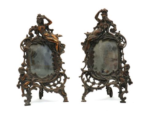 A pair of silver plated Art Nouveau easel back mirrors,early 20th century, each decorated with a semi clad maiden and putto, 