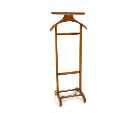 An Italian beech valet stand, 1970s, by Fratelli Reguitti, on castors, with gilt manufacturer's marks to the top, branded 'Ma