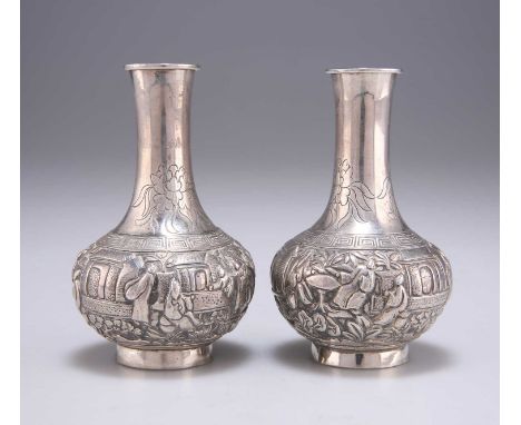 A PAIR OF CHINESE VASES retailed by Wang Hing &amp; Co, Hong Kong, late 19th/early 20th Century, bottle-shaped, chased with f
