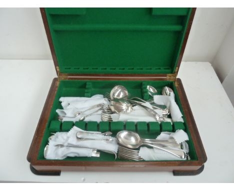 A part canteen of silver plated flatware, including shell pattern ladle, sugar tongs, forks and spoons, all in a walnut case