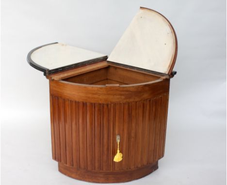 An Art Deco mahogany corner cabinet, hinged lid with ebonised border, over narrow panel doors, revealing shelf, 91cmW x 66cmD