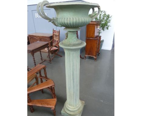 A composite urn with twin banded scrolling handles, on a Corinthian column style socle