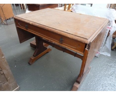 A Victorian oak sofa table, in Gothic taste, rectangular top and leaves, above angular N supports united by baluster stretche