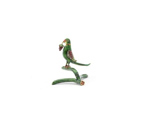 A gem-set enamelled gold parrot North India, 19th Centuryperching on a branch with erect body and tail, decorated in polychro