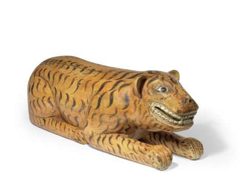 A painted wood model of a tiger India, 19th Centurythe recumbent creature facing forward with erect round ears, wide open eye