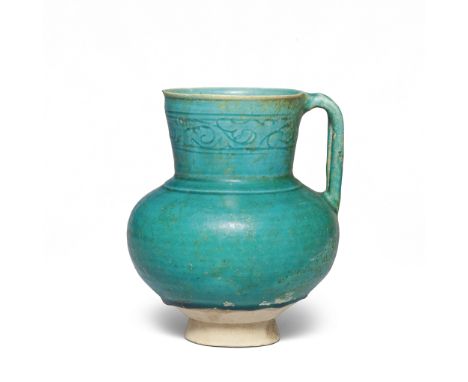 A Kashan monochrome pottery jug Persia, 12th Centuryof bulbous form with wide flaring neck on a splayed foot with strap handl