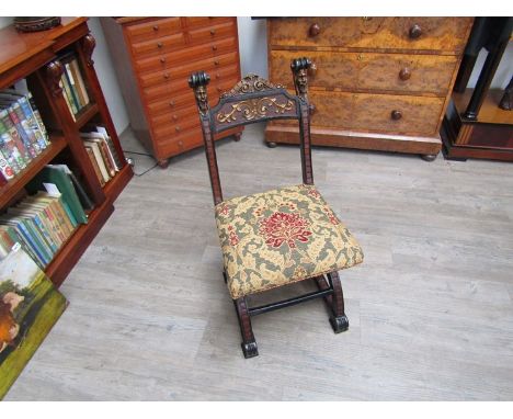 A Victorian polychrome painted hall chair with grotesque mask and gilt relief decoration over an X frame base on scroll foot 