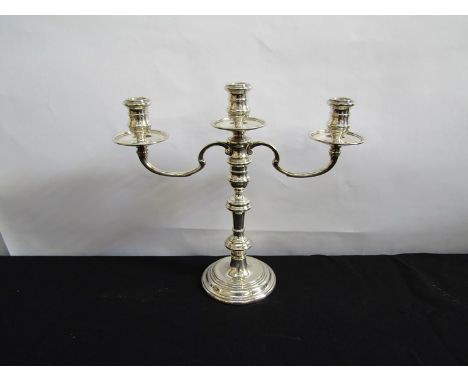 A silver three sconce candlestick, London 1903, weighted base, converts to single, 30cm tall