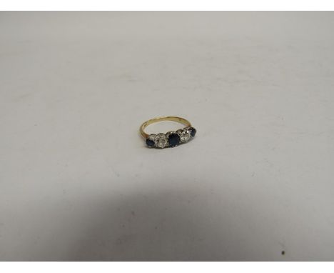 A gold five stone diamond and sapphire ring the central oval blue sapphire flanked by brilliant cut diamonds and smaller blue