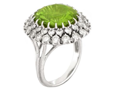 Vintage Oval Cut Peridot, Round Brilliant Cut Diamond and 14 Karat White Gold Ring. Peridot measures 15mm x 12.5mm. Stamped 1