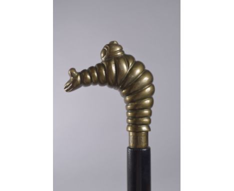 A WALKING STICK WITH MICHELIN MAN HANDLE.