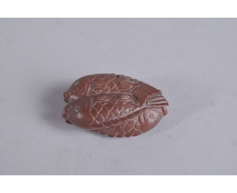 A WOODEN NETSUKE carved as four fishes. Signed.