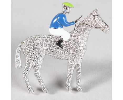 A SILVER AND ENAMEL JOCKEY ON HORSE BROOCH.