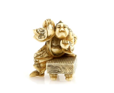 A stained ivory netsuke of an angry go player, standing by the go board and throwing a cup, signed SuzakuProvenance: The Prop