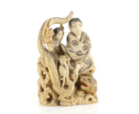 A stained ivory okimono carved as a man and boy beside a dragon and tiger, 12 cm high, signed HosaiProvenance: The Property o