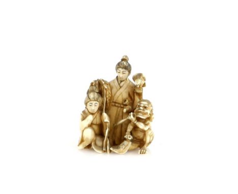 An ivory netsuke or small okimono carved as three figures, comprising a girl, an Oni, and a standing man with a bird-of-prey,