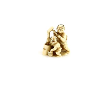 An ivory netsuke carved as two men surrounded by buckets whilst manufacturing dough, 19th or 20th CenturyProvenance: The Prop