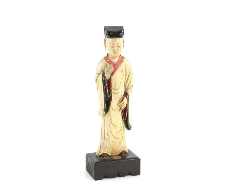 A Chinese ivory carving of a standing scholar, 21 cm high, Qing Dynasty, attached to a rectangular wood standProvenance: The 