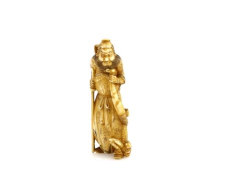 A stained ivory okimono carved as a standing Shoki holding a struggling Oni by the ankle, 9cm high, 20th CenturyProvenance: T