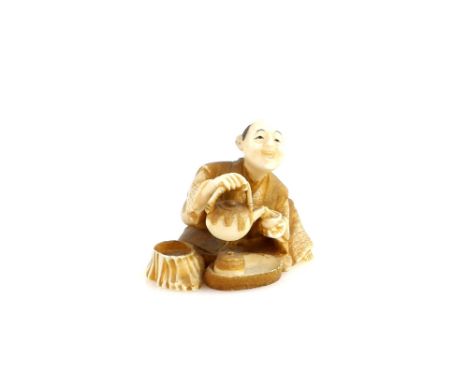 A heavily stained ivory netsuke of a man with a dobin pouring tea into a chawan, signed Kozan, 20th CenturyProvenance: The Pr