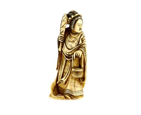 A small ivory okimono, carved as Seiobo, holding a fan in her right hand and a basket in her left hand, 7.5 cm high, 19th or 