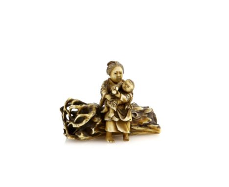 A small stained ivory netsuke or okimono of a mother, seated on a log with her child; two kanji on the log, Meiji PeriodProve