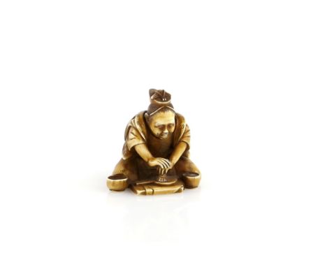 A stained ivory netsuke of a kneeling Kagamishi working on a mirror,  20th CenturyProvenance: The Property of a Lady. From a 
