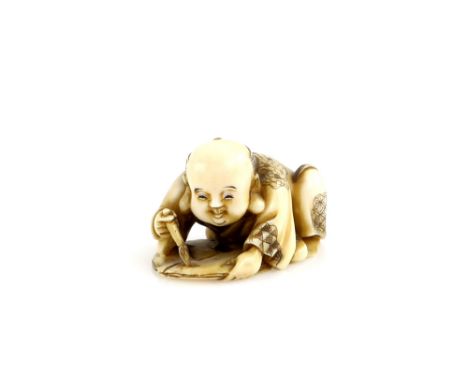 A stained ivory netsuke of a crouching Fukusuke, or other character, practising his calligraphy, signed SozanProvenance: The 