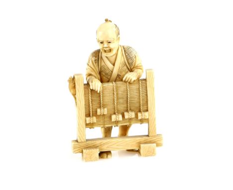 A stained ivory okimono of a Ratcatcher standing behind a screen, 9 cm high, Meiji PeriodProvenance: The Property of a Lady. 