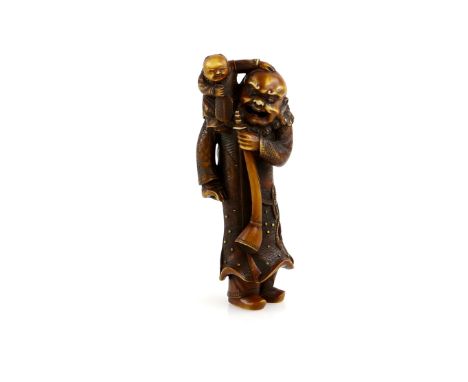 A heavily stained ivory netsuke carved as a Gaijin, holding a long horn with his left hand and with a young child on his righ