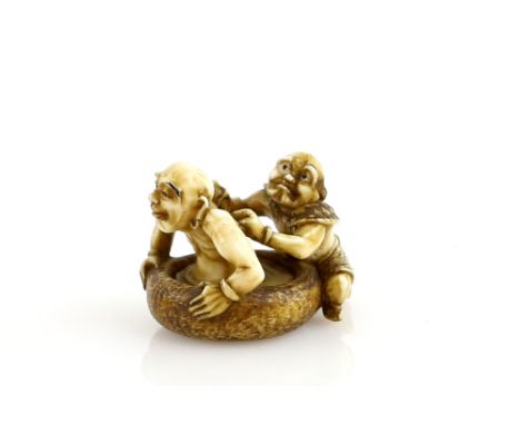 A stained ivory netsuke of an Oni scrubbing the back of a Rakan signed HogyokuProvenance: The Property of a Lady. From a Priv