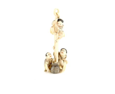 A stained ivory okimono of three boys beside a large anchor, 12 cm high, 20th CenturyProvenance: The Property of a Lady. From