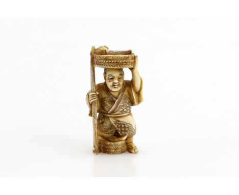 A stained ivory netsuke of a standing fish vendor, 20th CenturyProvenance: The Property of a Lady. From a Private Collection 