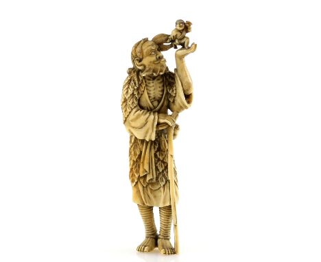 A stained ivory netsuke of Tekkai Sennin  with a gourd flask at his waist and holding a crutch with his right hand; his left 