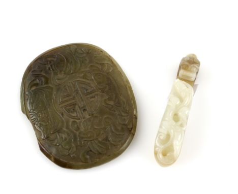A mottled green jade belt hook of typical curved form with reverse boss and animal head, 7.5 cm long, Qing Dynasty or later; 