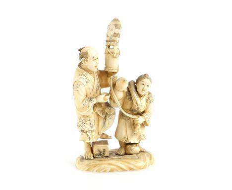 A sectional ivory okimono of a standing man and his son, the man holding aloft a Sambaso Dancer's head dress, 11cm,  Meiji Pe