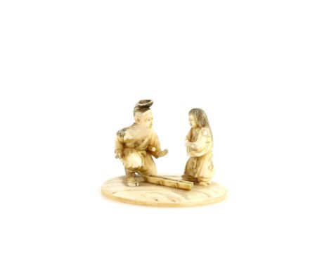 A stained ivory okimono on oval base, carved as a man wearing waraji and a ko-wakizashi beside a child with long hair, 6cm wi