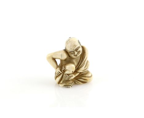 An ivory netsuke carved as barefoot patient applying traditional moxa to his right leg, signed Yoshinaga, early 19th  Century