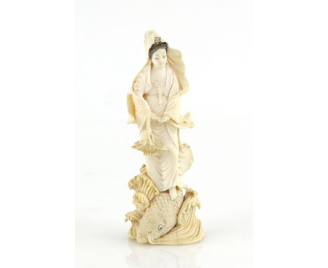 A small stained ivory okimono of Benten emerging from the waves beside a large carp, 9.5 cm high, 20th CenturyProvenance: The