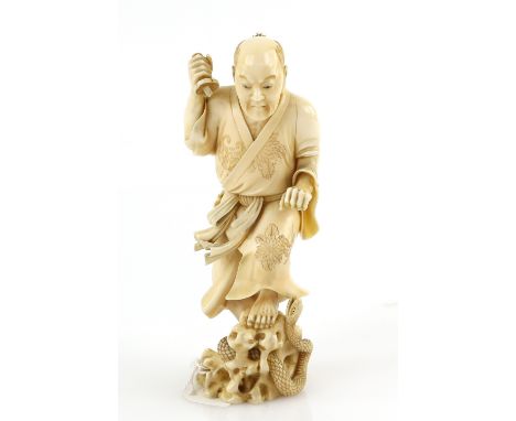 A stained ivory okimono, carved as a standing man killing a snake with a ko-wakizashi, 13 cm high, signed YugetsuProvenance: 