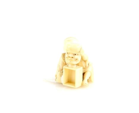 An ivory netsuke of a boy holding up a mask on a box, 19th CenturyProvenance: The Property of a Lady. From a Private Collecti