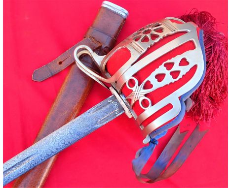 1950’s era British Army Scottish officer’s broad sword and scabbard by Wilkinson Sword. Features plated, nickel-pierced baske