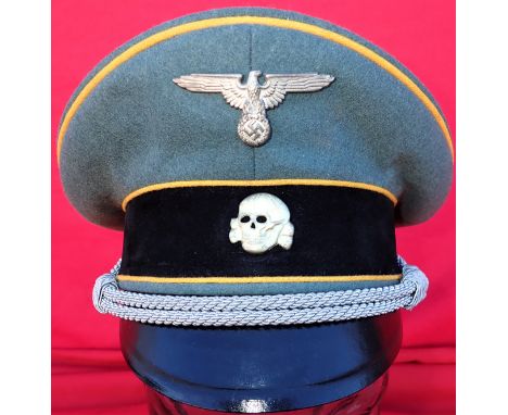 WW2 German S.S. Cavalry officer’s uniform peaked cap by Deutsche Wertarbeit. Features a field grey wool crown, with yellow ‘C
